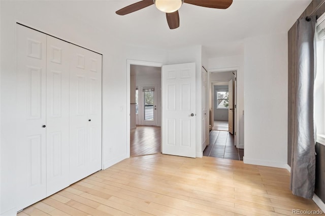 11 W Ellsworth Ave Unit 22, Denver, CO 80223 - unfurnished bedroom featuring multiple windows, wood finished floors, a closet, and baseboards
