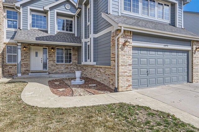 view of front of property with a garage, brick siding, roof with shingles, and concrete driveway