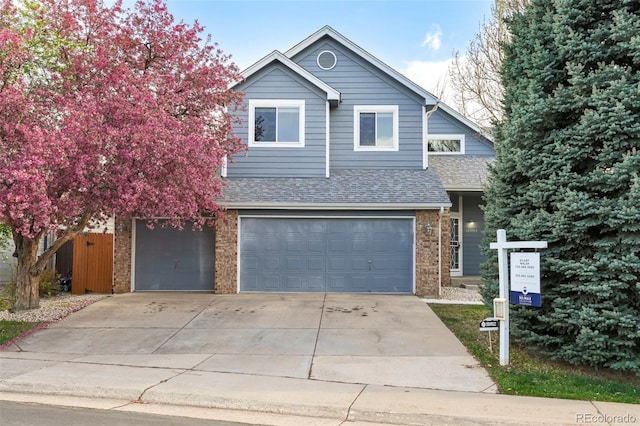 14084 E Hampden Pl, Aurora, CO 80014 - view of front of house with a shingled roof, brick siding, driveway, and a garage