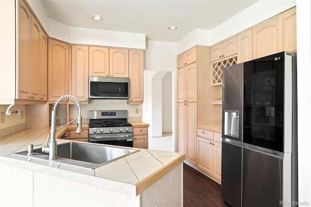14084 E Hampden Pl, Aurora, CO 80014 - kitchen with a sink, a peninsula, light brown cabinetry, and appliances with stainless steel finishes