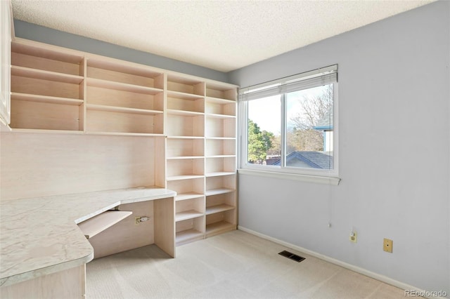 14084 E Hampden Pl, Aurora, CO 80014 - unfurnished office with built in desk, a textured ceiling, visible vents, baseboards, and light carpet