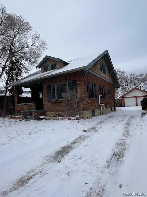 view of front of property with a garage, an outdoor structure, and a porch