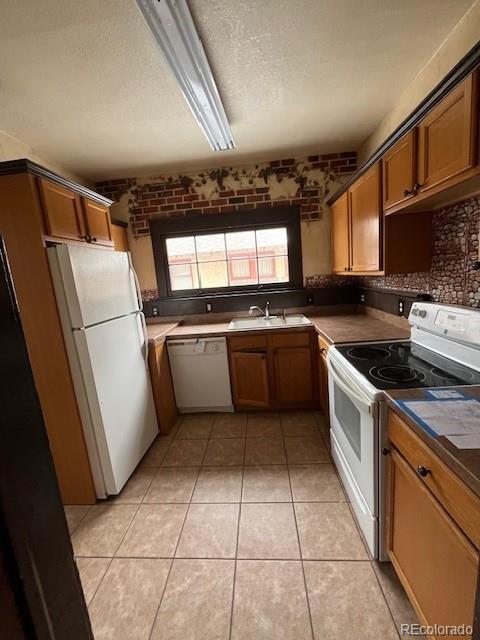 kitchen with sink, white appliances, backsplash, a textured ceiling, and light tile patterned flooring