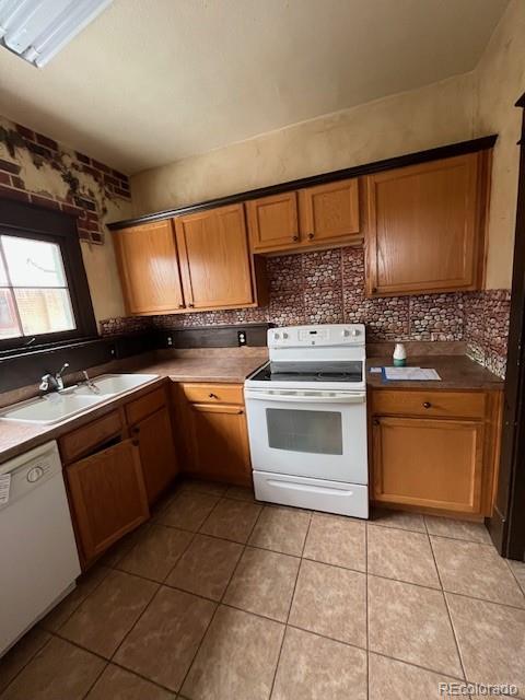 kitchen featuring sink, light tile patterned floors, white appliances, and decorative backsplash