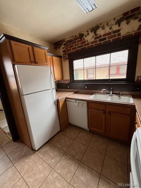 kitchen featuring white appliances, sink, a textured ceiling, and light tile patterned floors