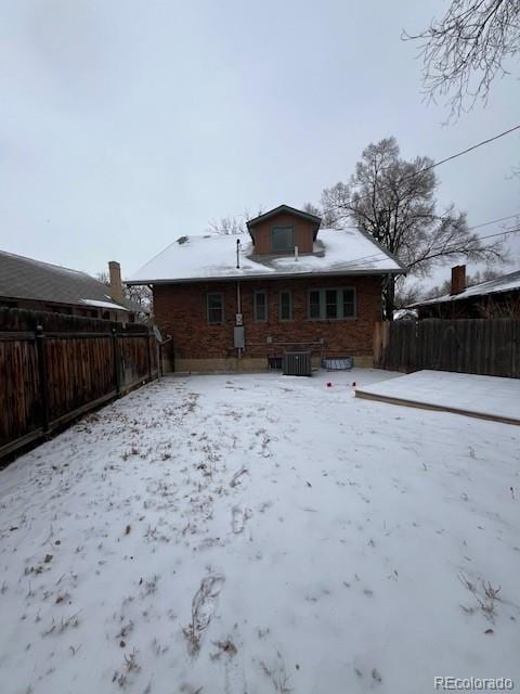 snow covered rear of property with central air condition unit