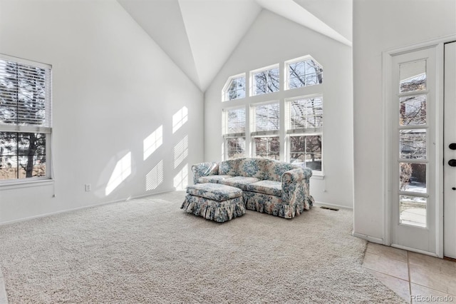 living area featuring light colored carpet and high vaulted ceiling