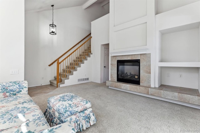 living room with a towering ceiling, light colored carpet, and a fireplace