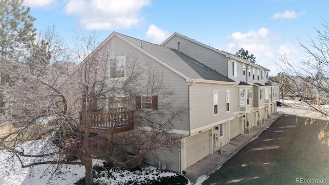 view of snow covered exterior with a garage