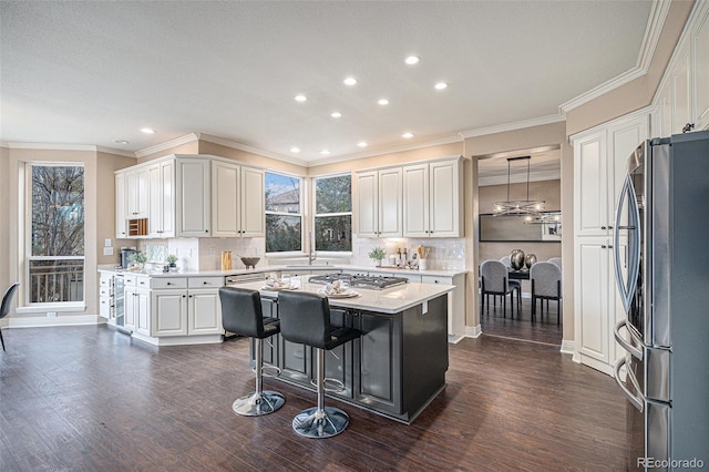 kitchen featuring a center island, decorative light fixtures, stainless steel appliances, light countertops, and white cabinetry