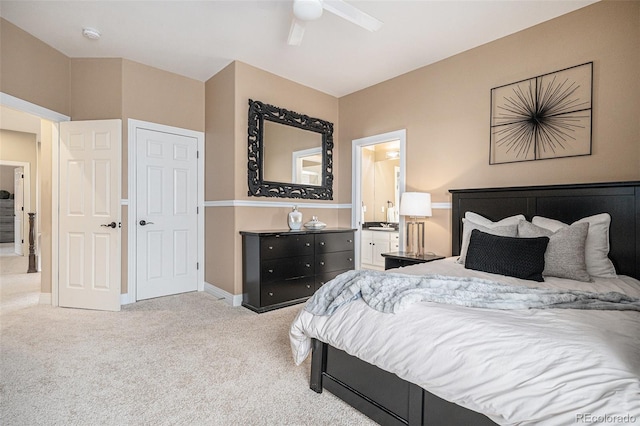 bedroom with baseboards, ceiling fan, ensuite bathroom, and light colored carpet