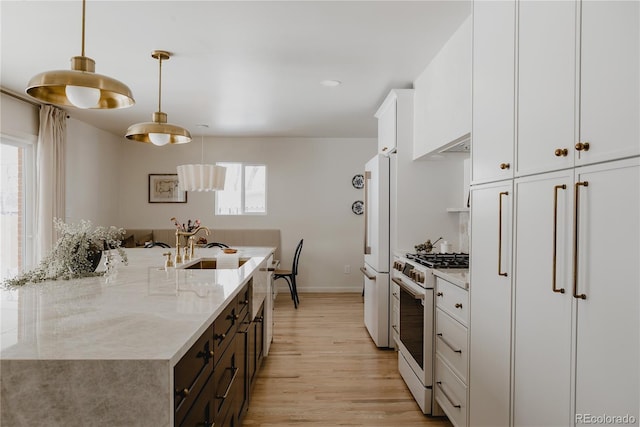 kitchen with decorative light fixtures, white cabinetry, white appliances, light stone countertops, and light wood-type flooring