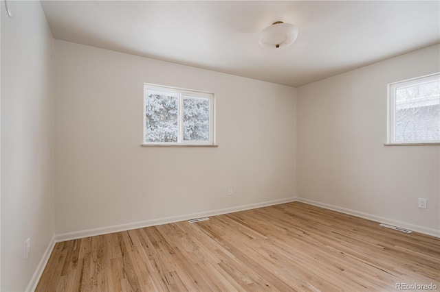 empty room with plenty of natural light and light wood-type flooring