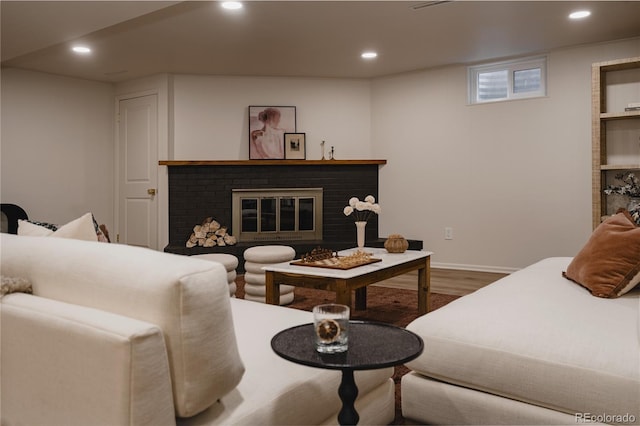 living room featuring hardwood / wood-style flooring and a brick fireplace