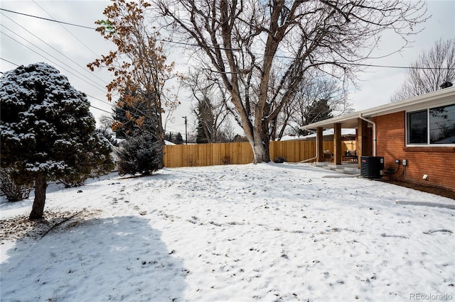 snowy yard featuring central AC