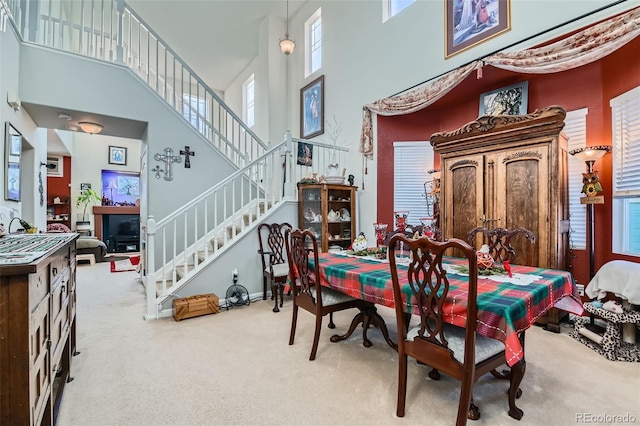 carpeted dining area featuring a high ceiling