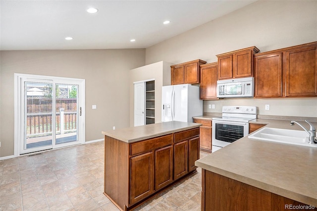 kitchen featuring white appliances, a kitchen island, lofted ceiling, and sink