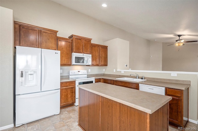 kitchen with a center island, white appliances, sink, ceiling fan, and kitchen peninsula