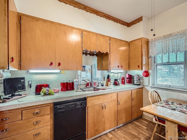 kitchen featuring sink, ornamental molding, light wood-type flooring, black dishwasher, and tasteful backsplash