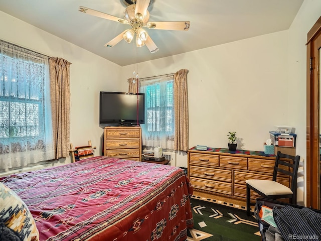 carpeted bedroom with multiple windows and ceiling fan