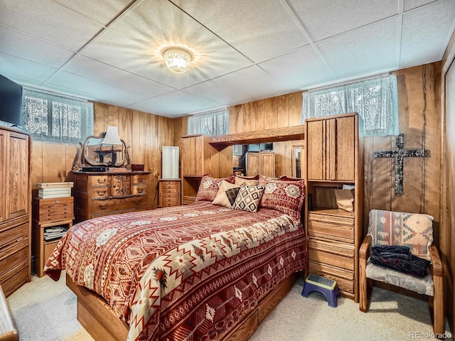 bedroom with wood walls and a drop ceiling