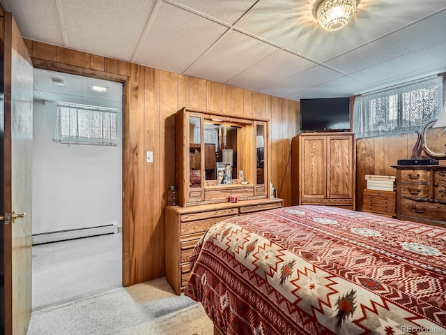 bedroom with wooden walls, light colored carpet, and a baseboard radiator