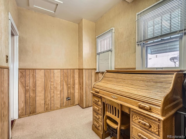 carpeted home office featuring wood walls