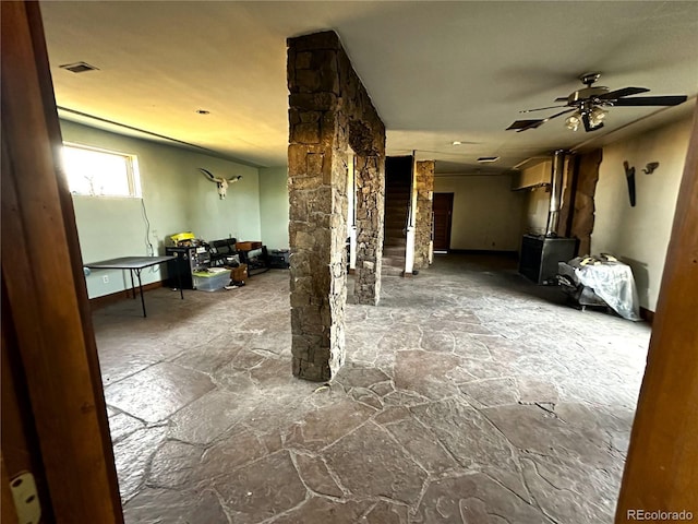 6558 Rio Blanco Rd, Hartsel, CO 80449 - living area with stone flooring, ornate columns, a ceiling fan, and a wood stove