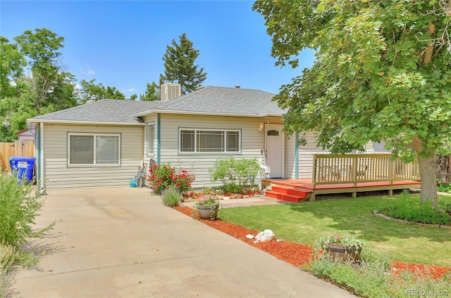 ranch-style house featuring a front yard, cooling unit, and a wooden deck