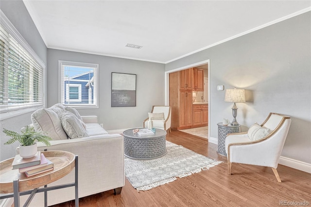 living room with crown molding and light hardwood / wood-style flooring