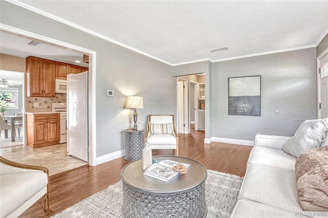 living room with light hardwood / wood-style flooring and crown molding