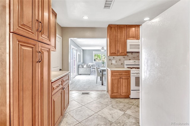 kitchen with decorative backsplash, white appliances, and light tile patterned floors