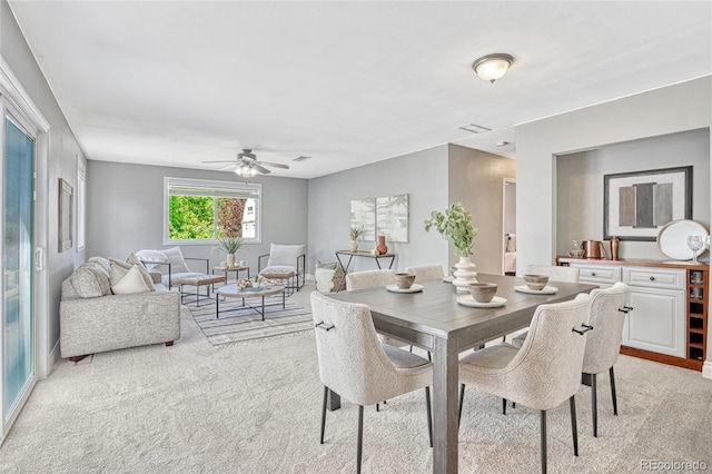 carpeted dining space featuring ceiling fan