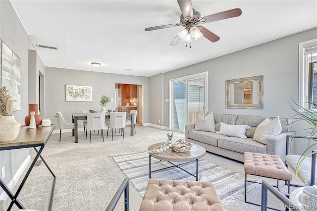 carpeted living room featuring ceiling fan