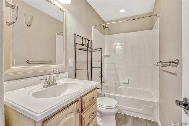 full bathroom featuring hardwood / wood-style floors, vanity, toilet, and bathtub / shower combination