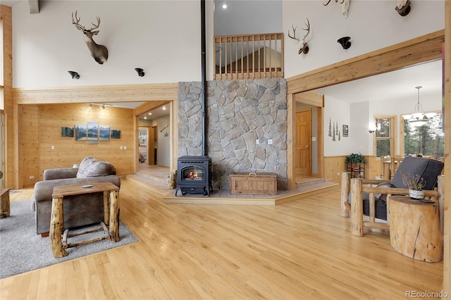 29266 S Sunset Trl, Conifer, CO 80433 - living area with wooden walls, a wood stove, wood finished floors, a high ceiling, and beamed ceiling