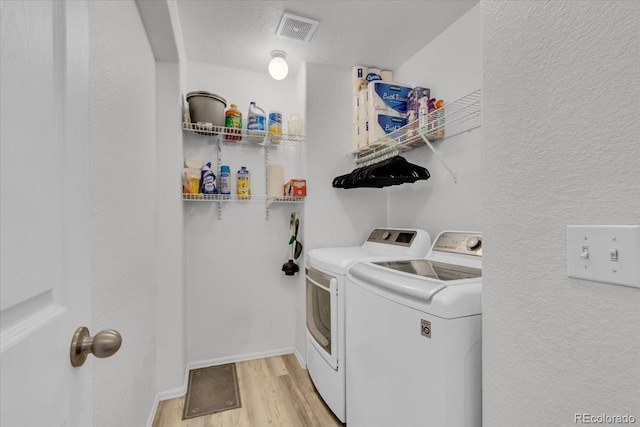 9758 Laredo St Unit 35B, Commerce City, CO 80022 - laundry room featuring separate washer and dryer, light wood-type flooring, a textured wall, and baseboards
