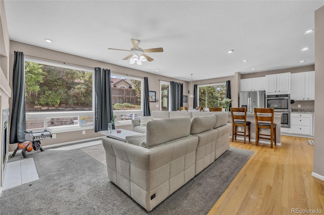 2938 S Zeno Way, Aurora, CO 80013 - living room with a ceiling fan, light wood-style floors, and recessed lighting