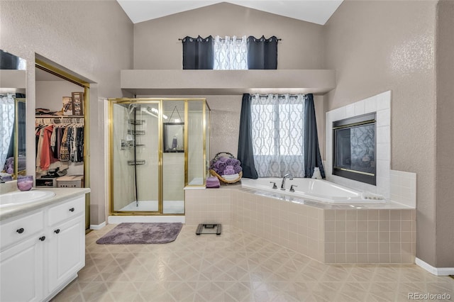 2938 S Zeno Way, Aurora, CO 80013 - full bathroom featuring vaulted ceiling, a stall shower, a bath, vanity, and a walk in closet