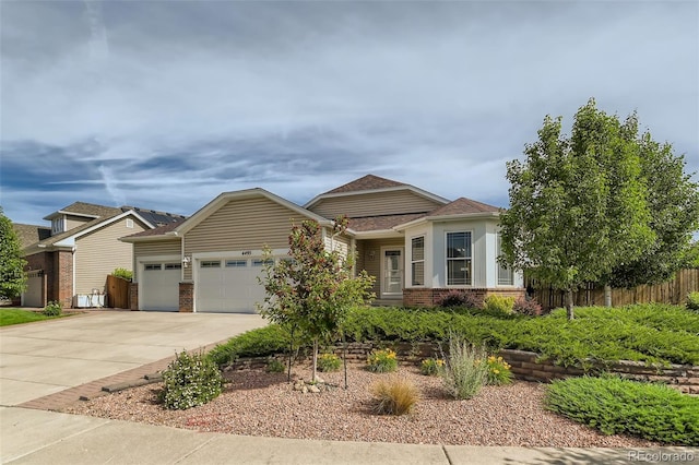 view of front of house featuring a garage, concrete driveway, brick siding, and fence