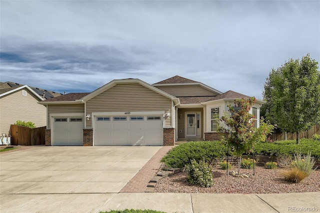 view of front facade with concrete driveway, brick siding, fence, and an attached garage