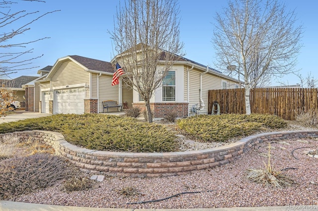 view of home's exterior featuring a garage, fence, concrete driveway, and brick siding