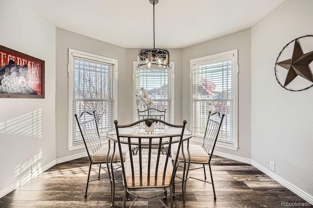 dining area featuring baseboards, dark wood finished floors, and a notable chandelier