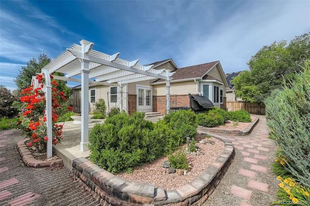 exterior space with brick siding, a patio area, fence, and a pergola