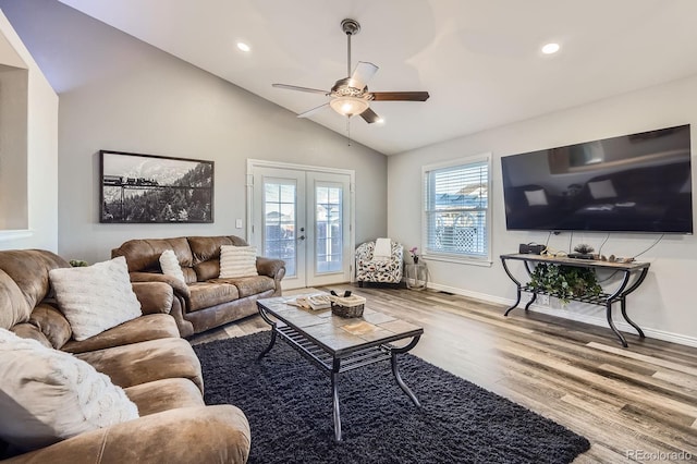 living area featuring lofted ceiling, baseboards, wood finished floors, and french doors