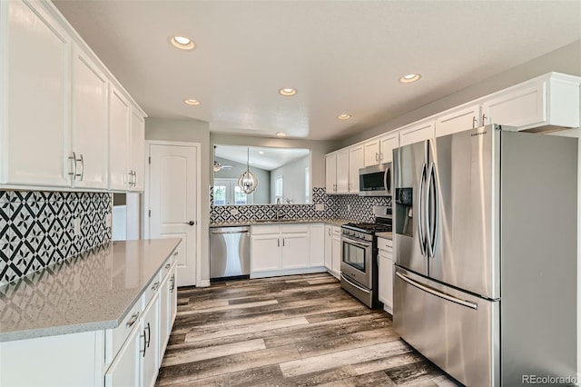 kitchen with white cabinets, a sink, stainless steel appliances, and dark wood-type flooring