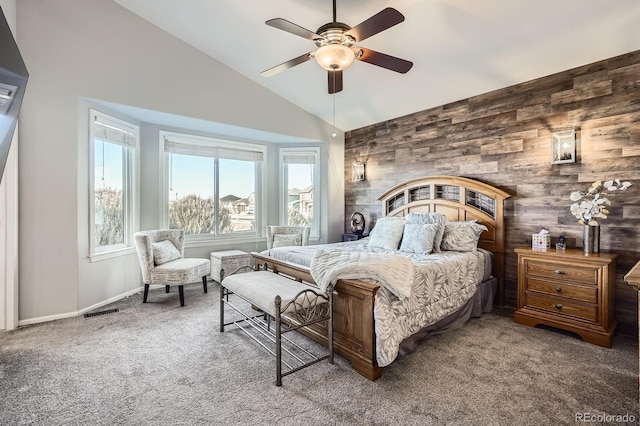 bedroom featuring lofted ceiling, wood walls, carpet flooring, and visible vents