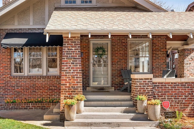 entrance to property featuring brick siding