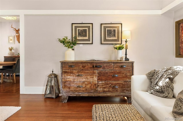 sitting room with dark wood finished floors and baseboards