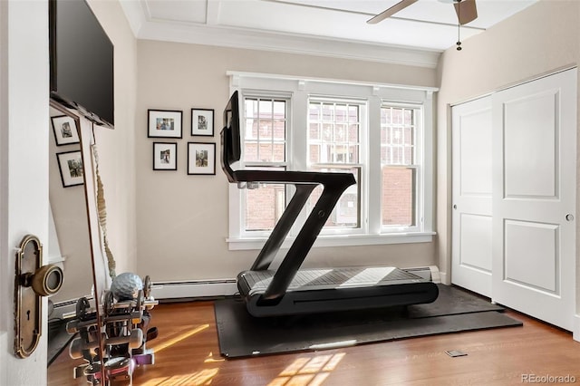 workout area featuring crown molding, a baseboard radiator, baseboard heating, ceiling fan, and wood finished floors